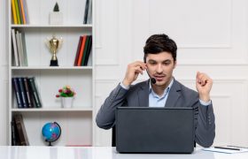 customer service cute guy grey suit with computer headset having videocall 280x180